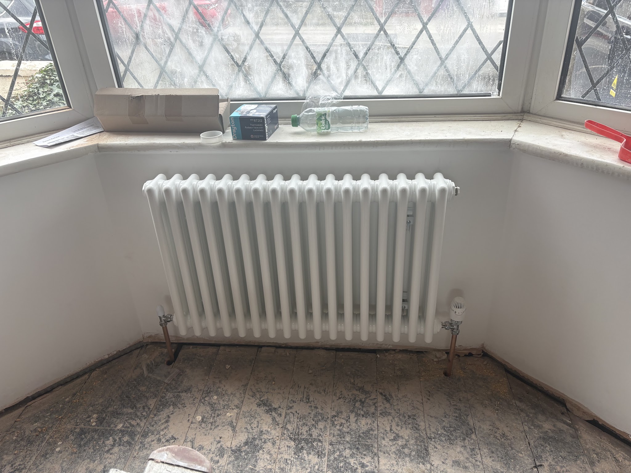 A column radiator fitted under a bay window